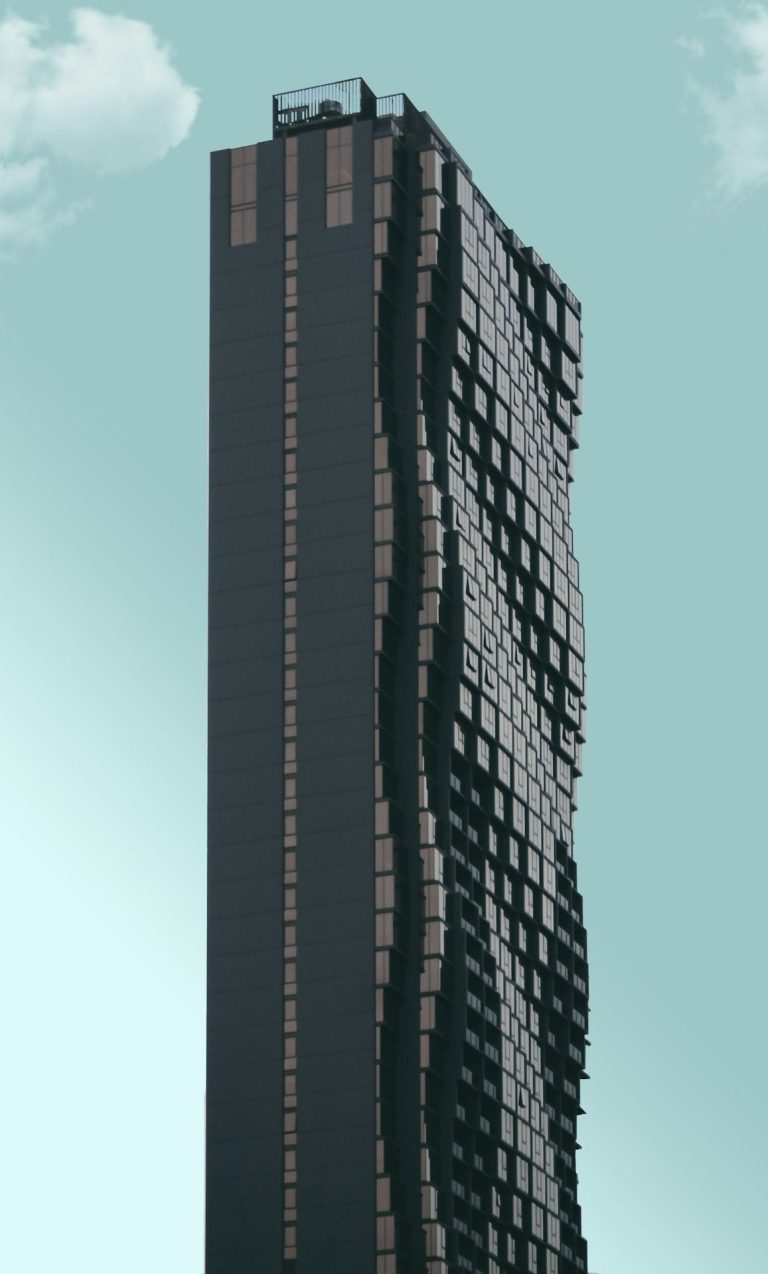 Tall, curved building with a textured facade against a clear sky.